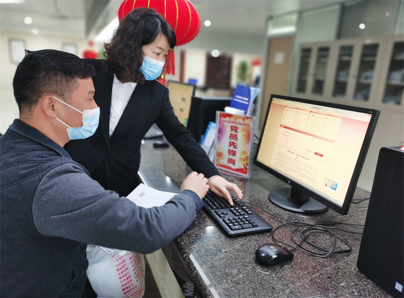 /QJ_490997560014.jpg 工作人員細(xì)心指導(dǎo)競價人完善競價資料(麥玉寧 攝).jpg